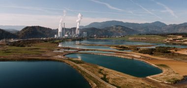 An aerial shot of a landscape surrounded by mountains and lakes with industrial disaster