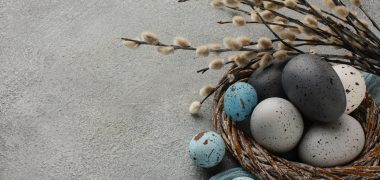 high-angle-colored-easter-eggs-basket-with-copy-space-twigs